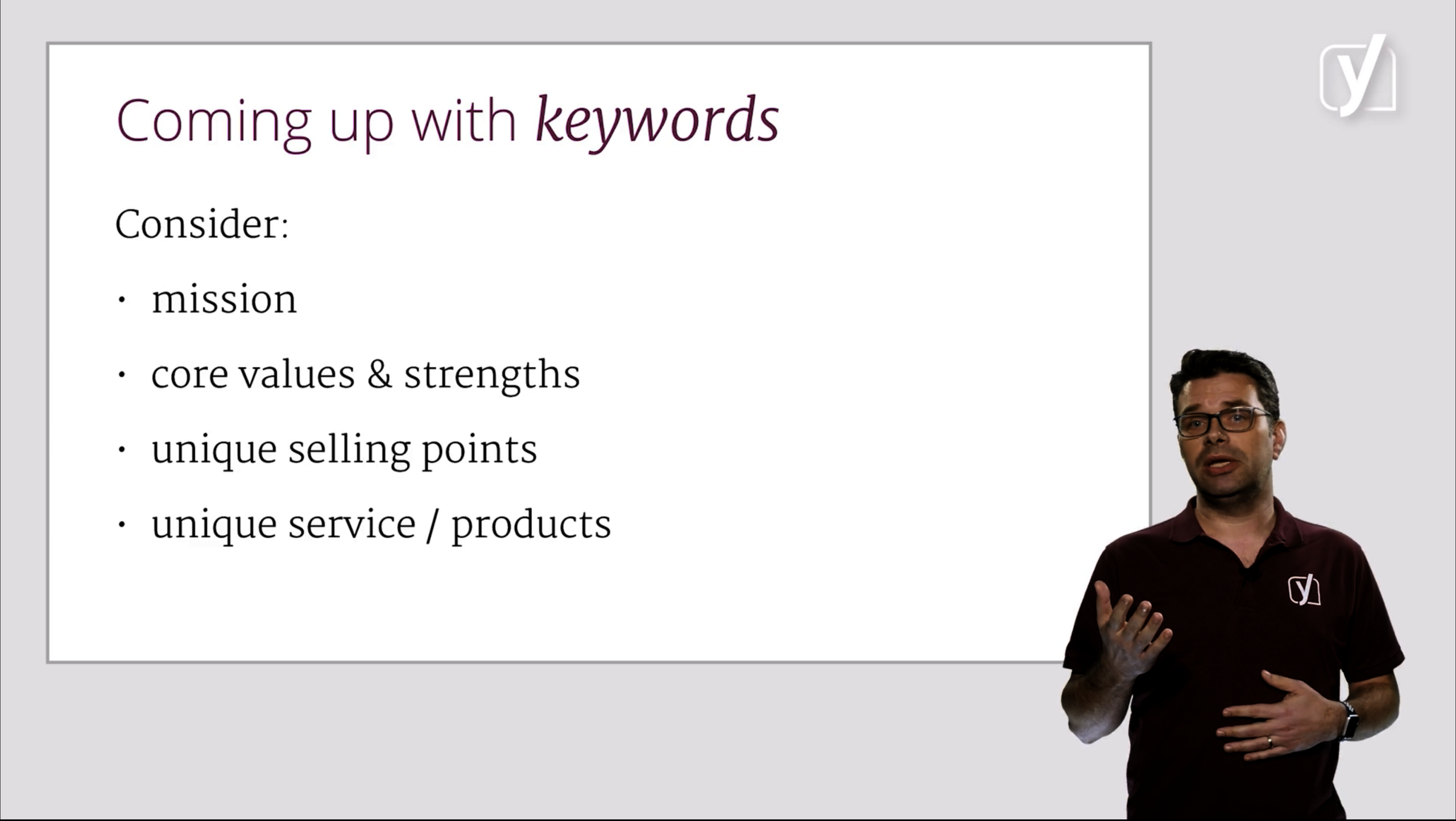 An instructor stands beside a slide titled "Coming up with keywords," listing mission, core values and strengths, unique selling points, and unique service or products.